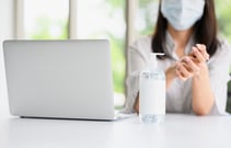 alcohol-gel-bottle-with-woman-wearing-facemask-washing-her-hand